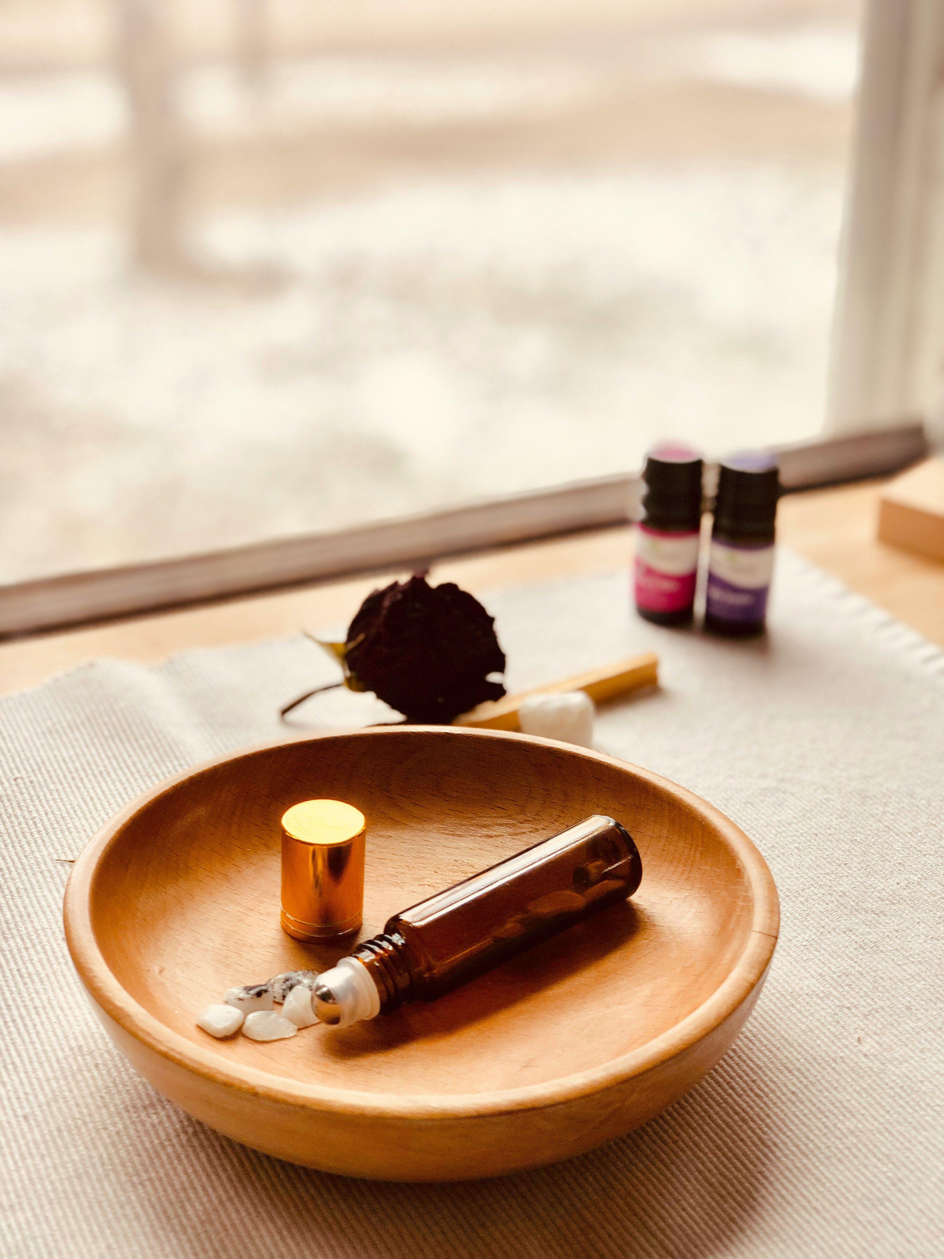 a bottle of essential oils on a wooden plate