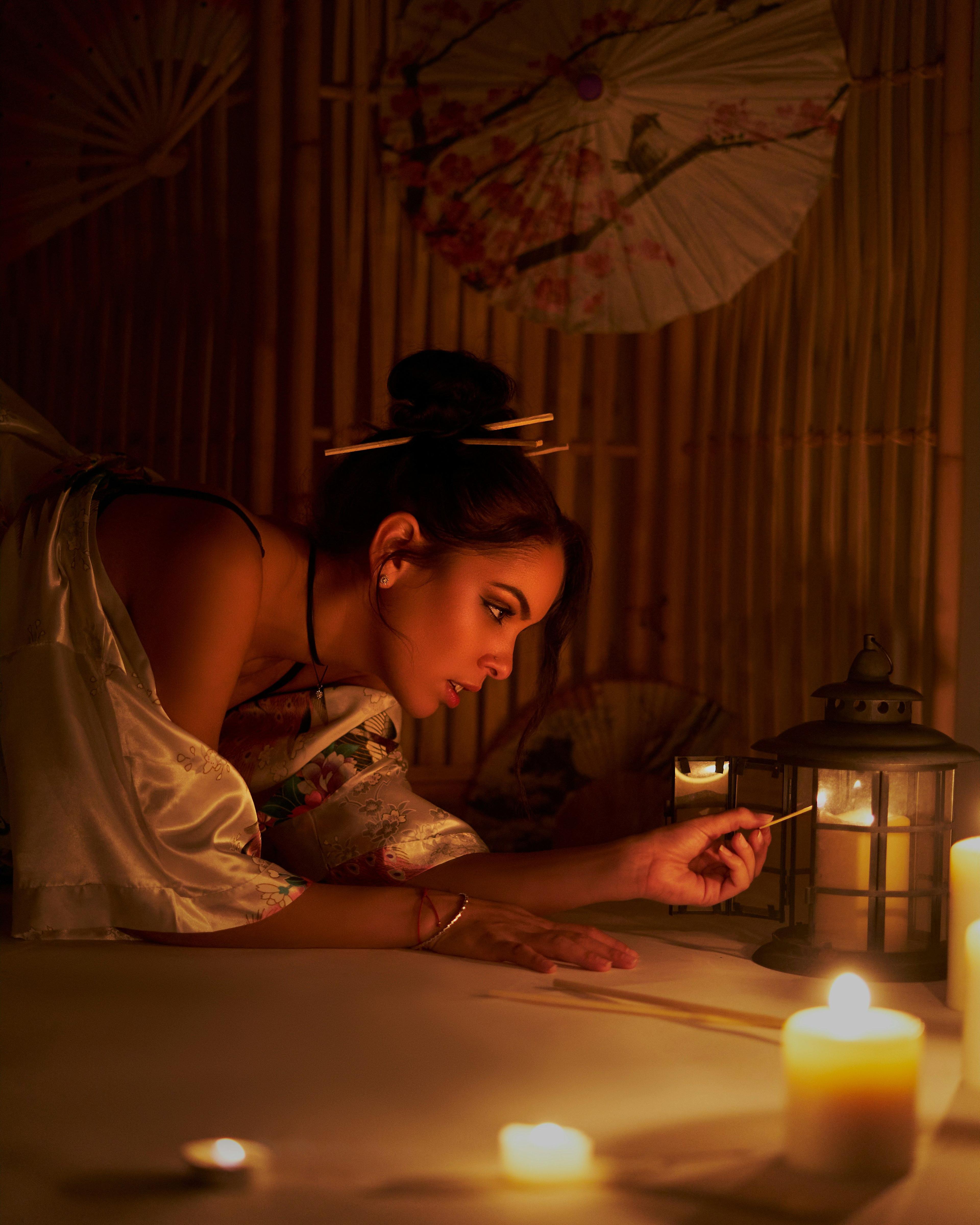 a woman is looking at a candle on a table