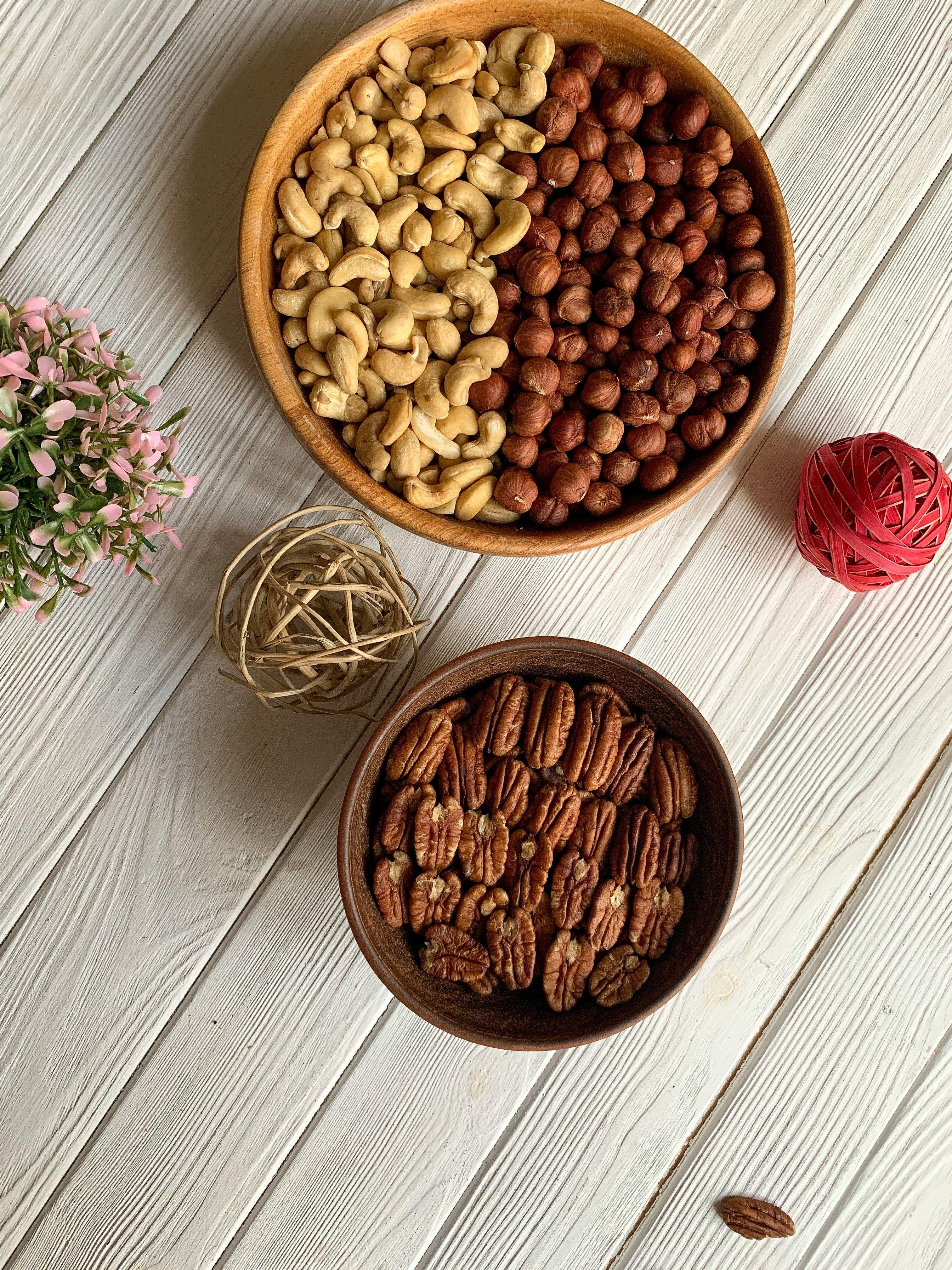 a bowl of nuts next to a bowl of string