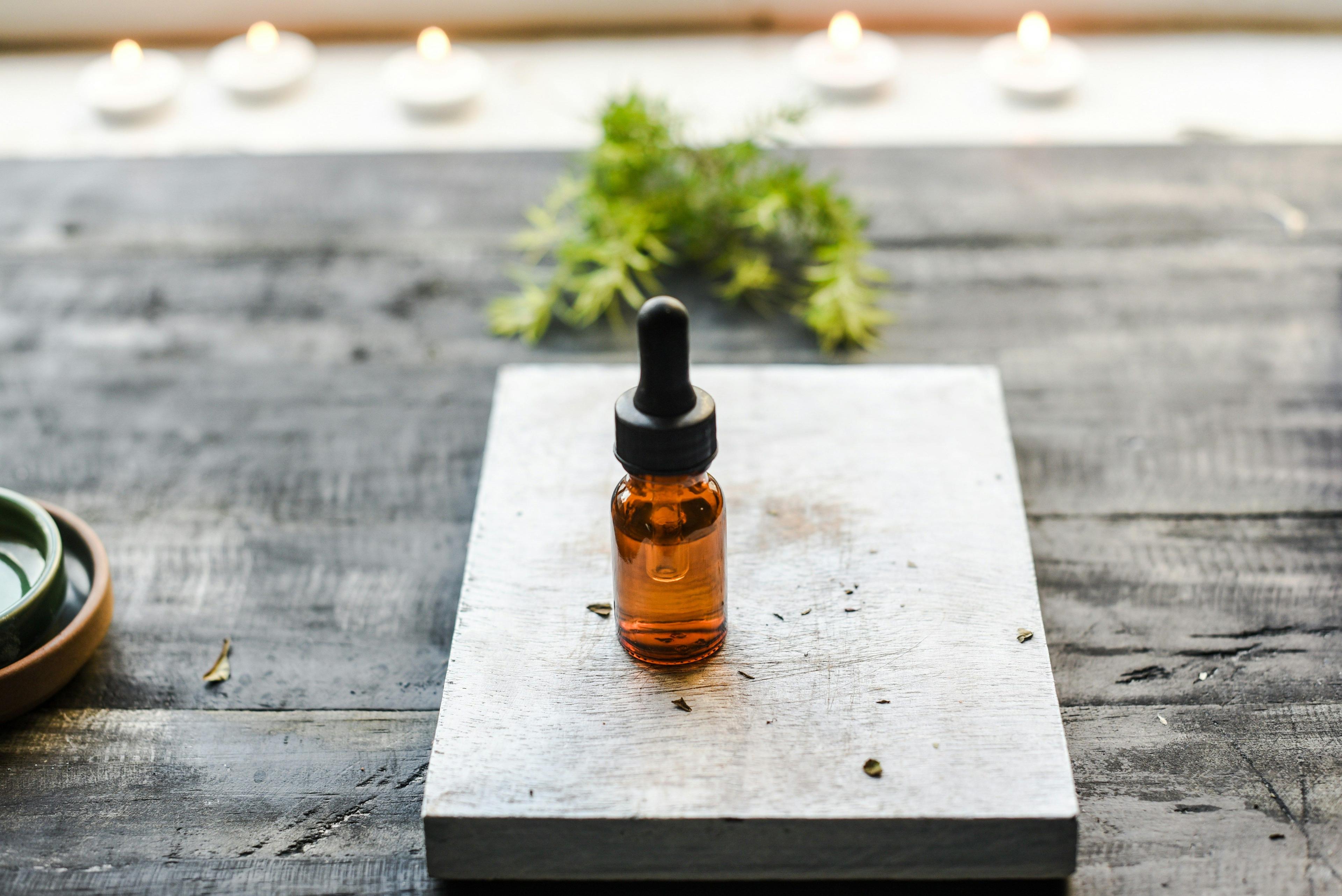 a bottle of essential oil sitting on top of a wooden table