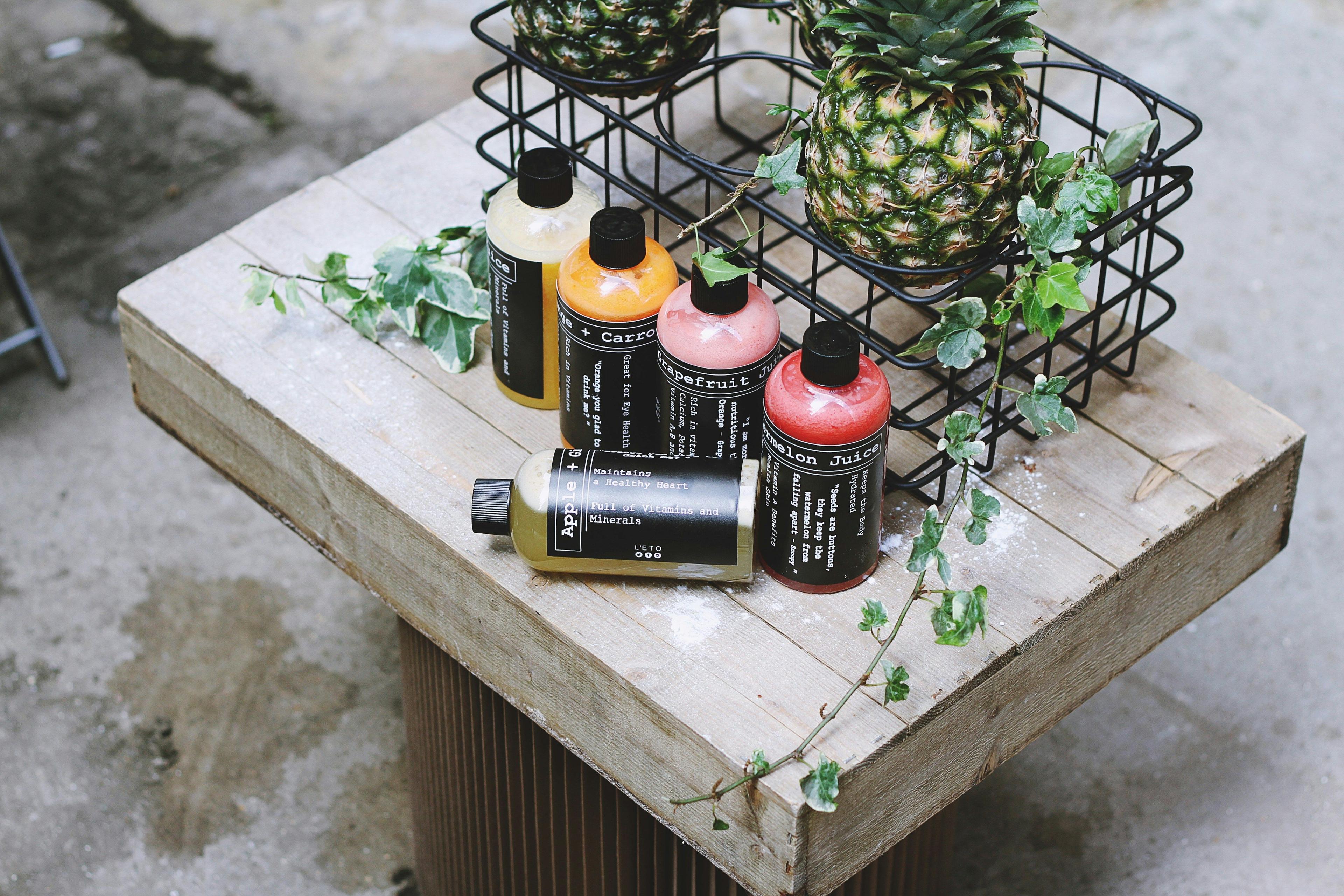 a wooden table topped with bottles of paint and a pineapple