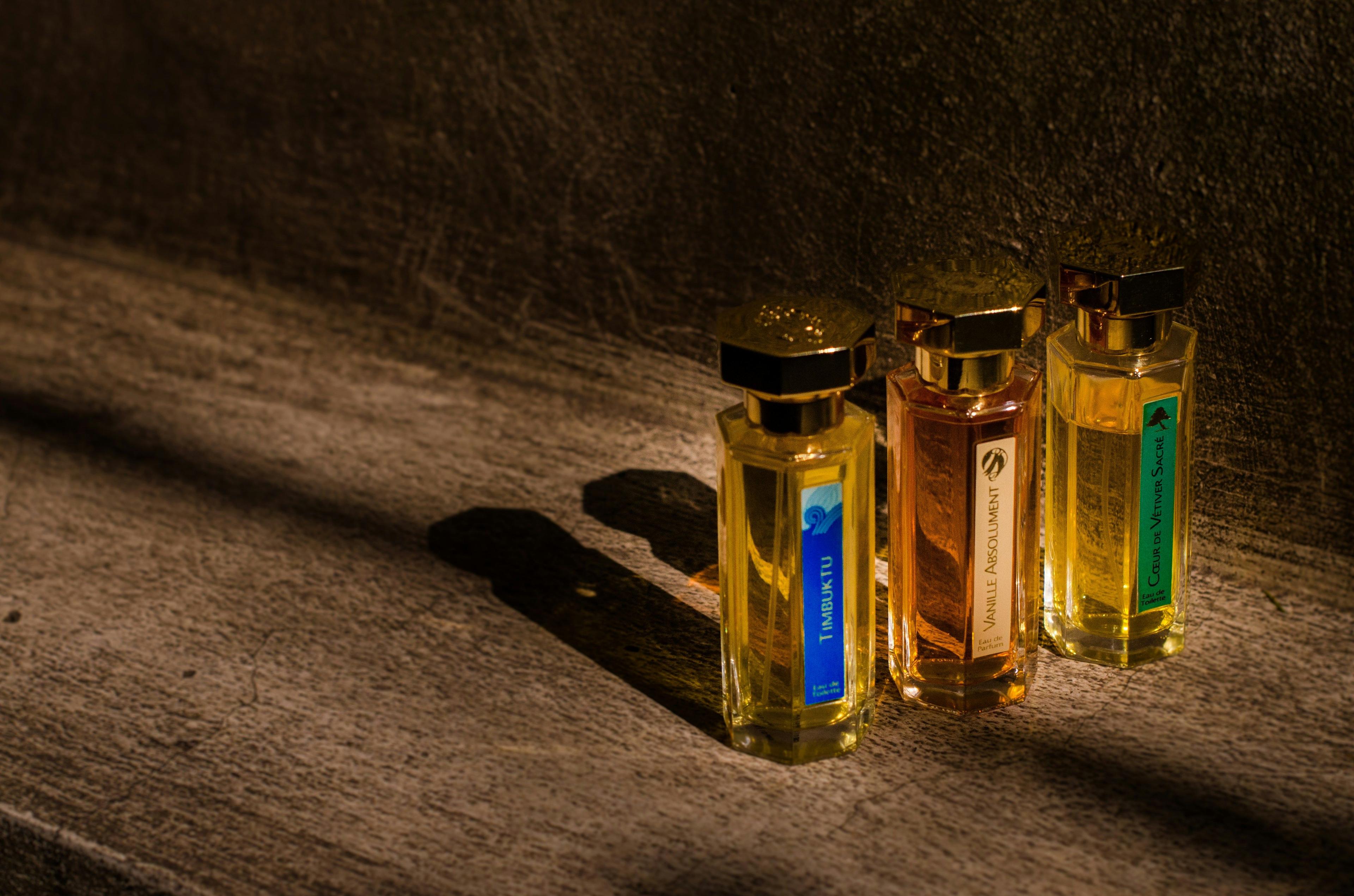 three bottles of perfume sitting on a table