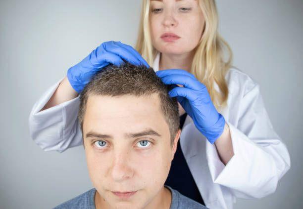 a doctor is examining a man's hair