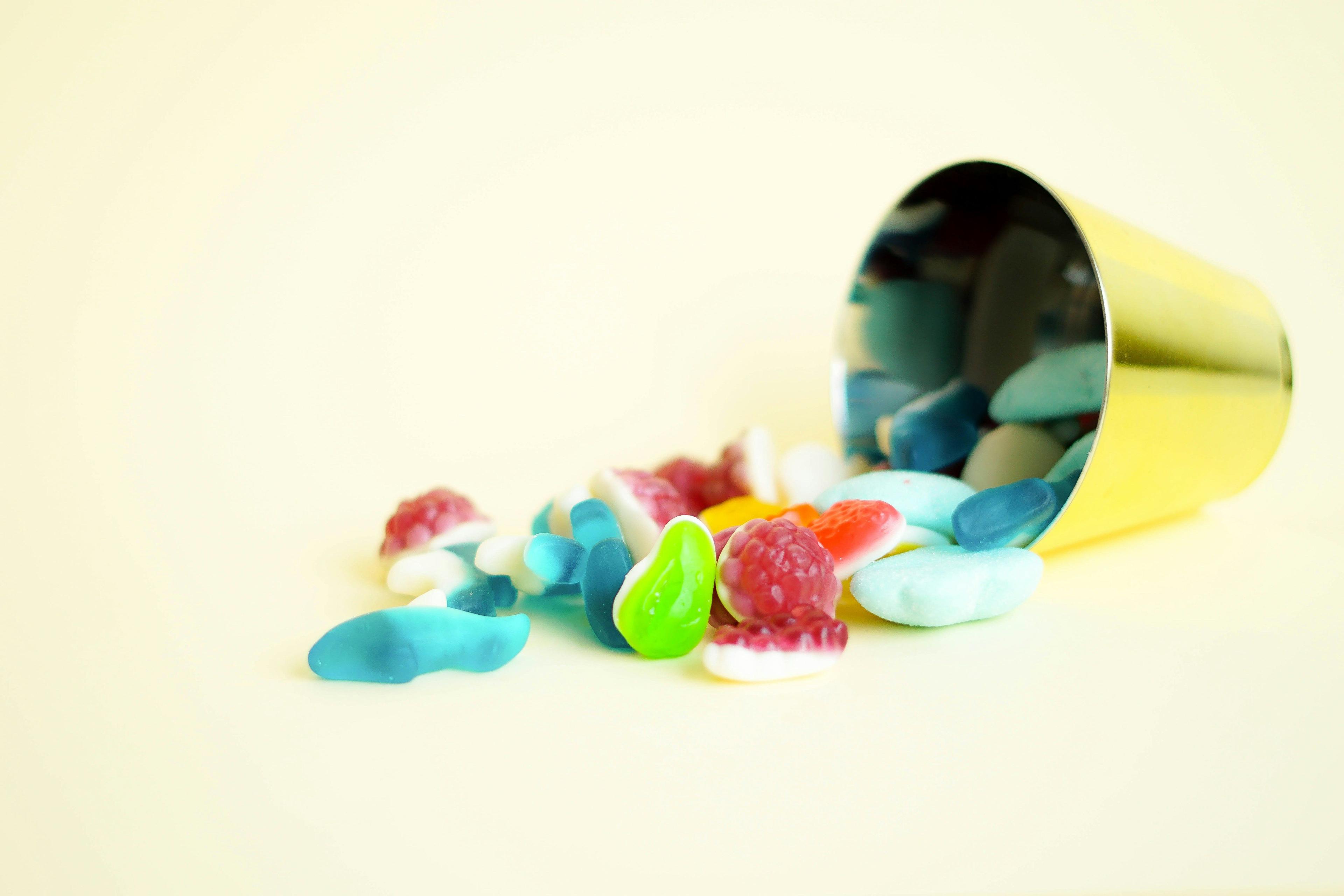 a yellow cup filled with gummy bears on top of a table