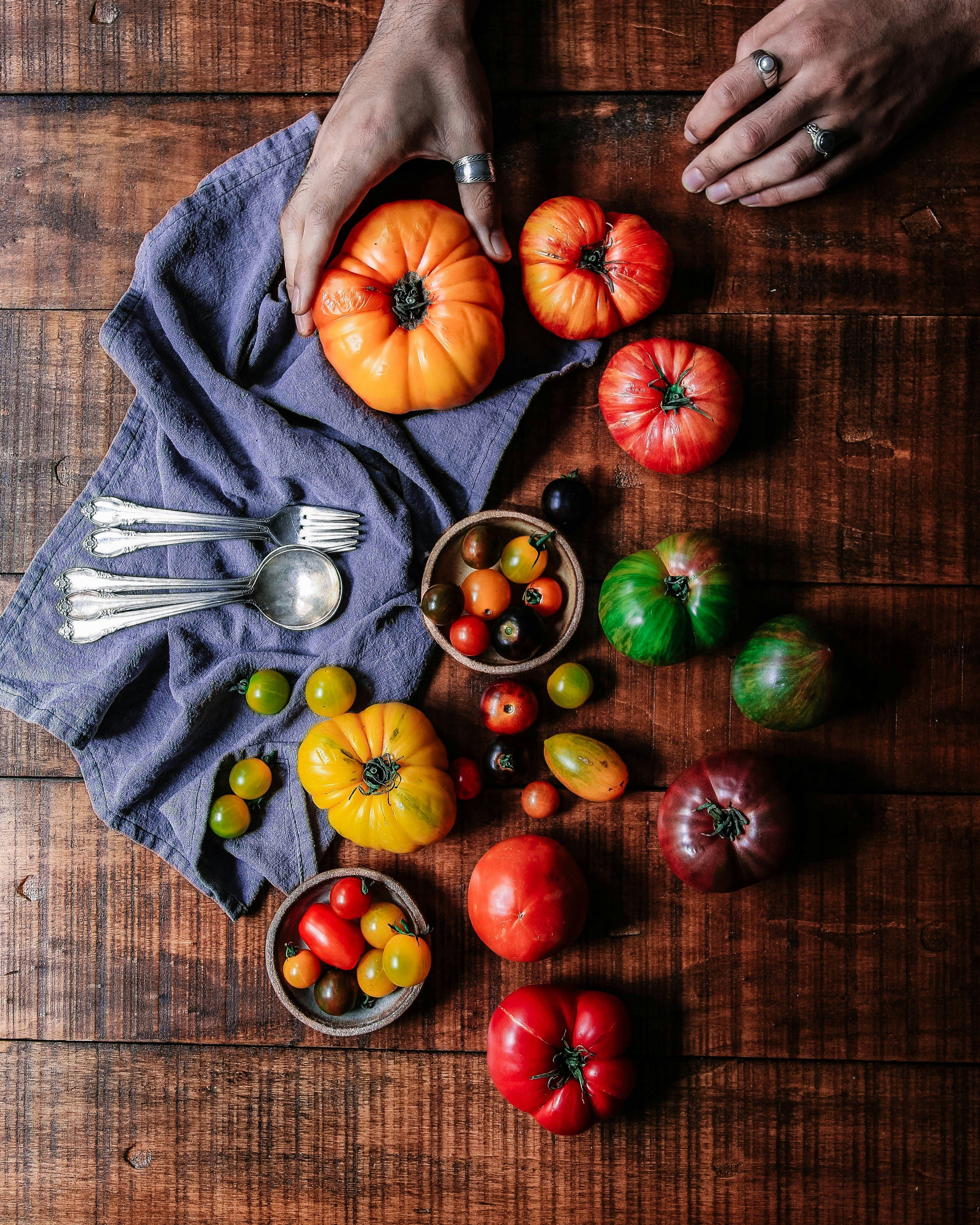 a wooden table topped with lots of different types of fruits and vegetables