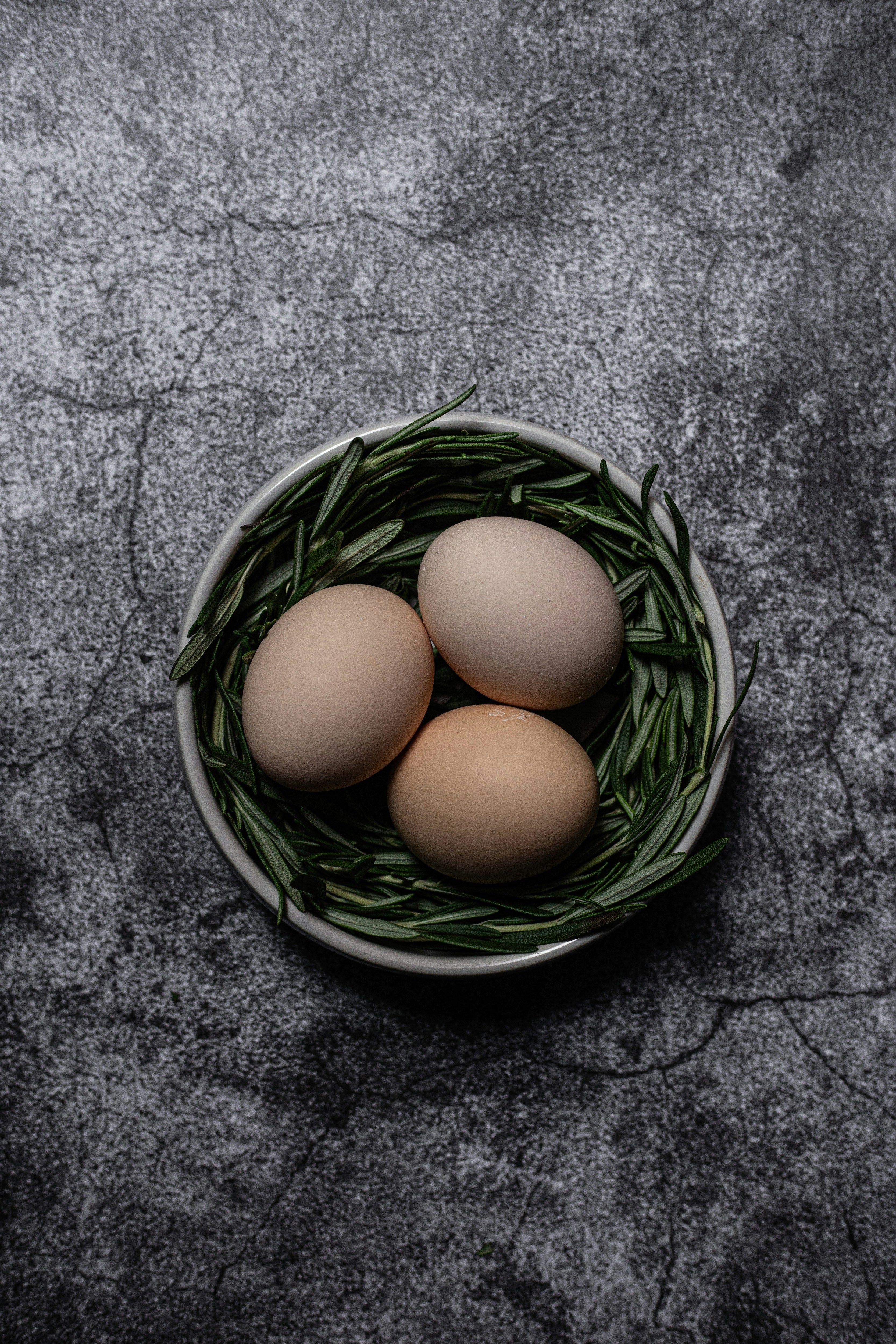 three eggs in a bowl on a table