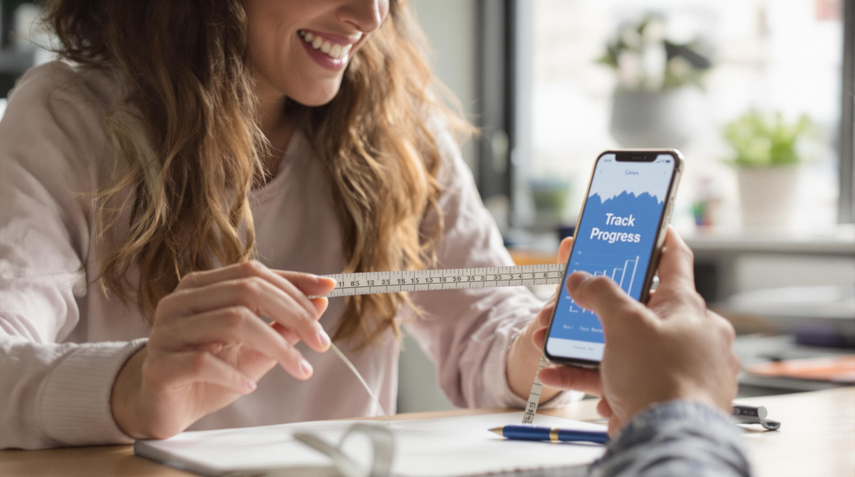Person measuring hair and using phone hair progress tracking app.