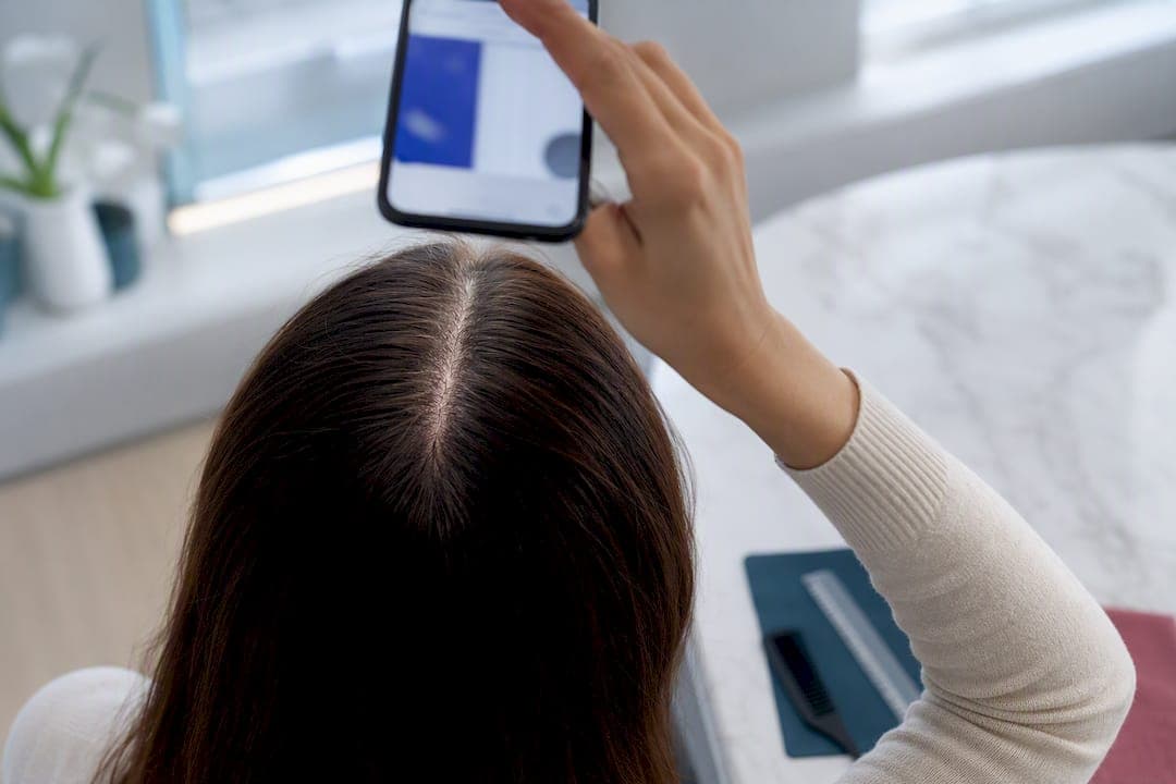 Person capturing a repeat scalp analysis photo